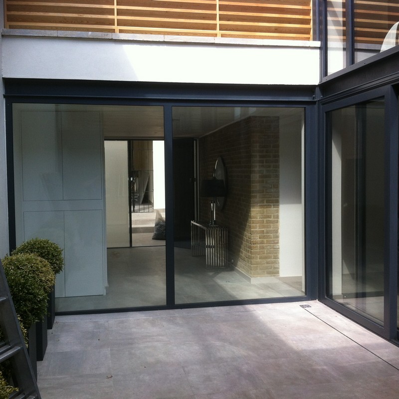 Floor-to-ceiling sliding doors opening to courtyard in Waltham Abbey