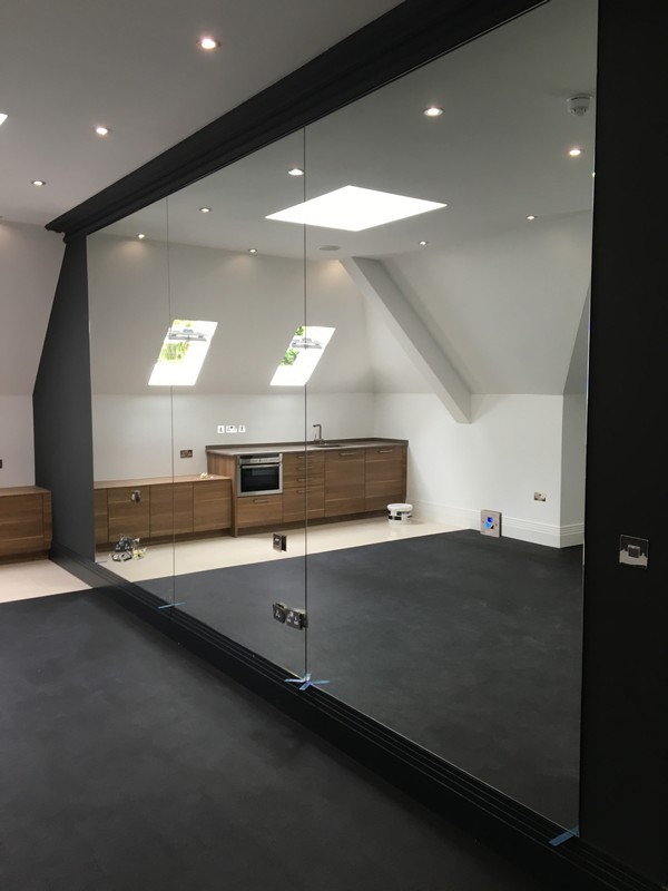 Frameless glass partition in loft conversion by Waltham Abbey glaziers