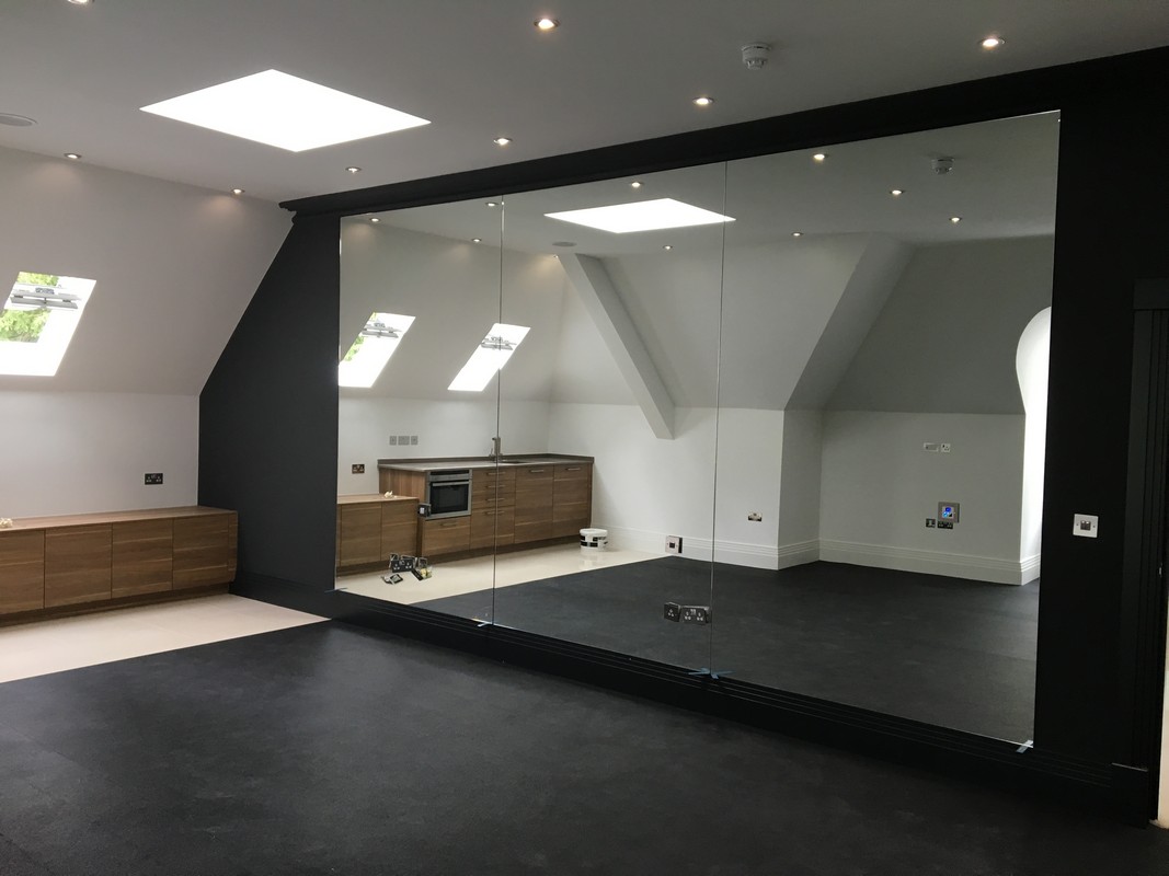 Frameless glass wall dividing loft conversion in Waltham Abbey